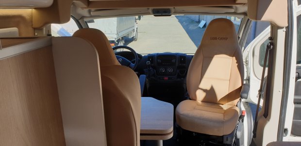 Wnętrze kampera: przednie fotele i składany stolik między nimi