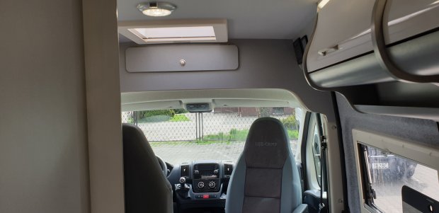 Wnętrze kampera: przednie fotele, kokpit, schowek nad kabiną i świetlik.