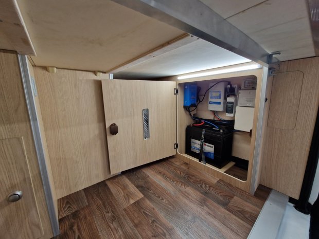 Szafka z akumulatorem, przetwornicą i przewodami w wnętrzu kampera