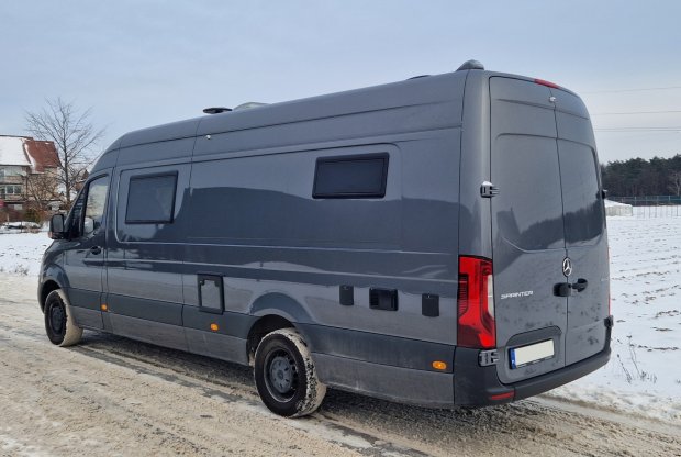 Szary van Mercedes Sprinter zaparkowany na ośnieżonej drodze.