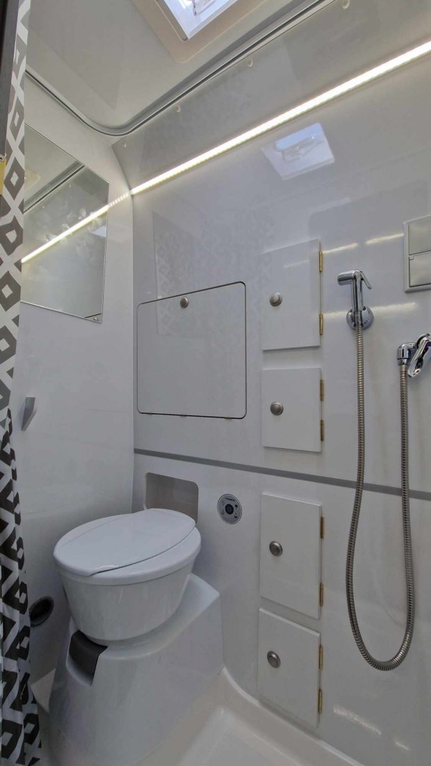 Mała łazienka w kamperze: toaleta, prysznic z giętkim wężem i szafki